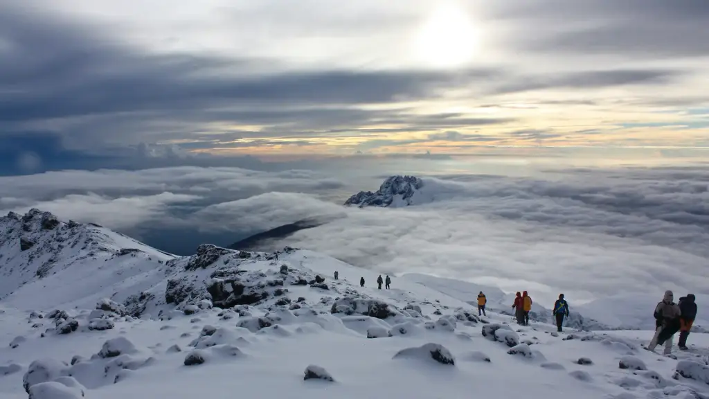 Climbers crossing snow above the clouds on Kilimanjaro