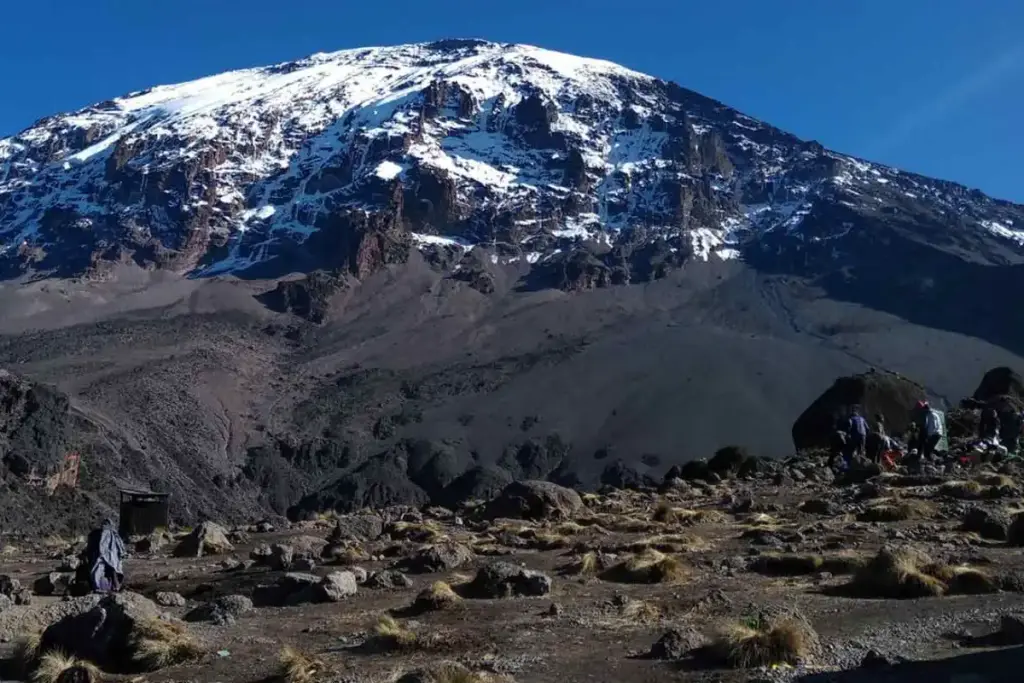 The snow-capped peak of Kilimanjaro above a rocky alpine desert