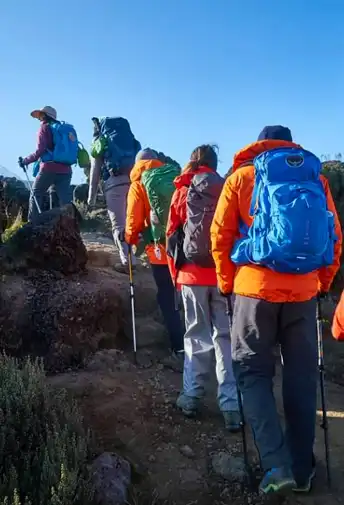 Climbers in bright jackets hiking in single file